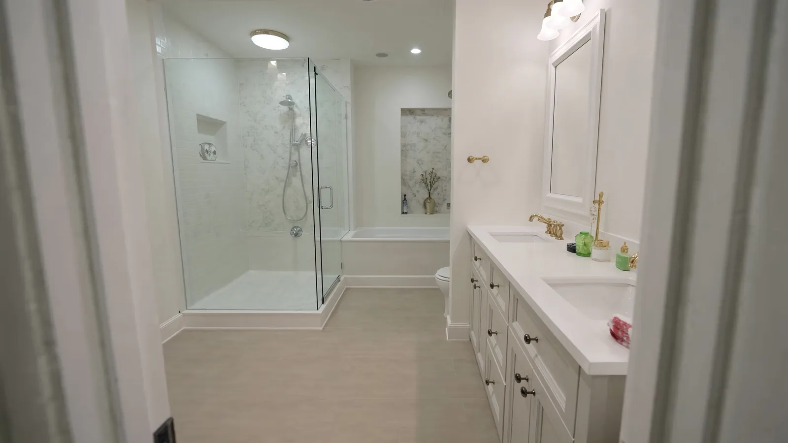 The same bathroom after remodel — curbless zero-entry shower, subway tile walls, floating vanity, and brushed nickel fixtures